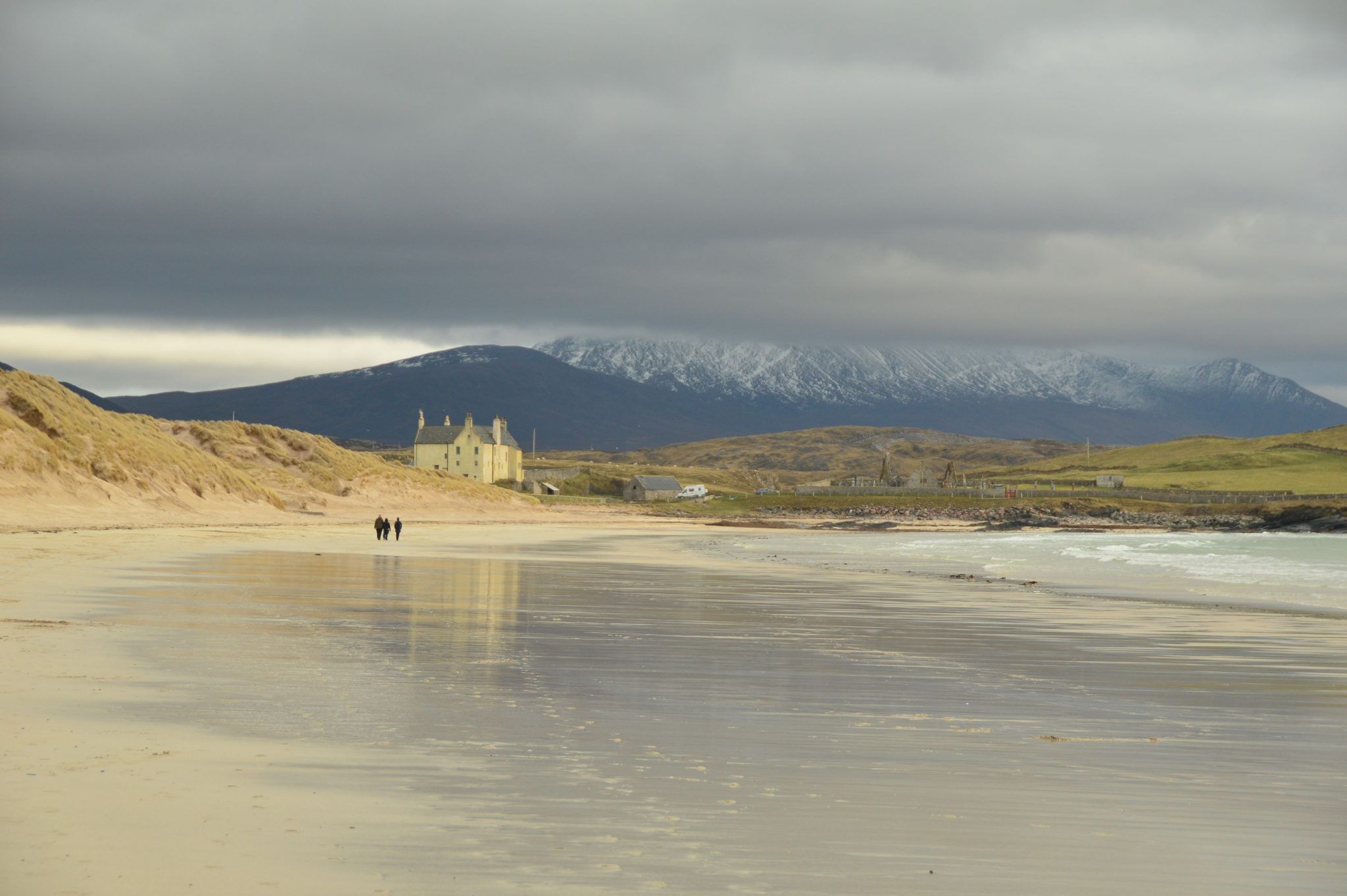 long view of Durness Beach with estate house and mountains in the distance