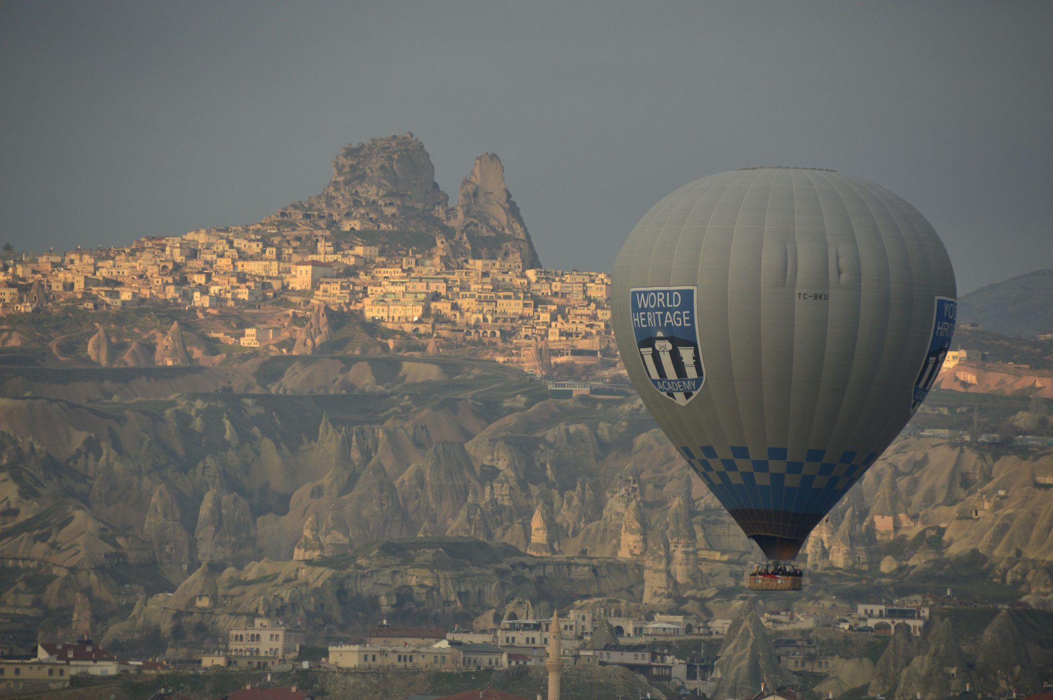 Perfect Cappadocia Itinerary 3 Days 8 Hot air balloon with uchisar town behind it in Cappadocia turkey
