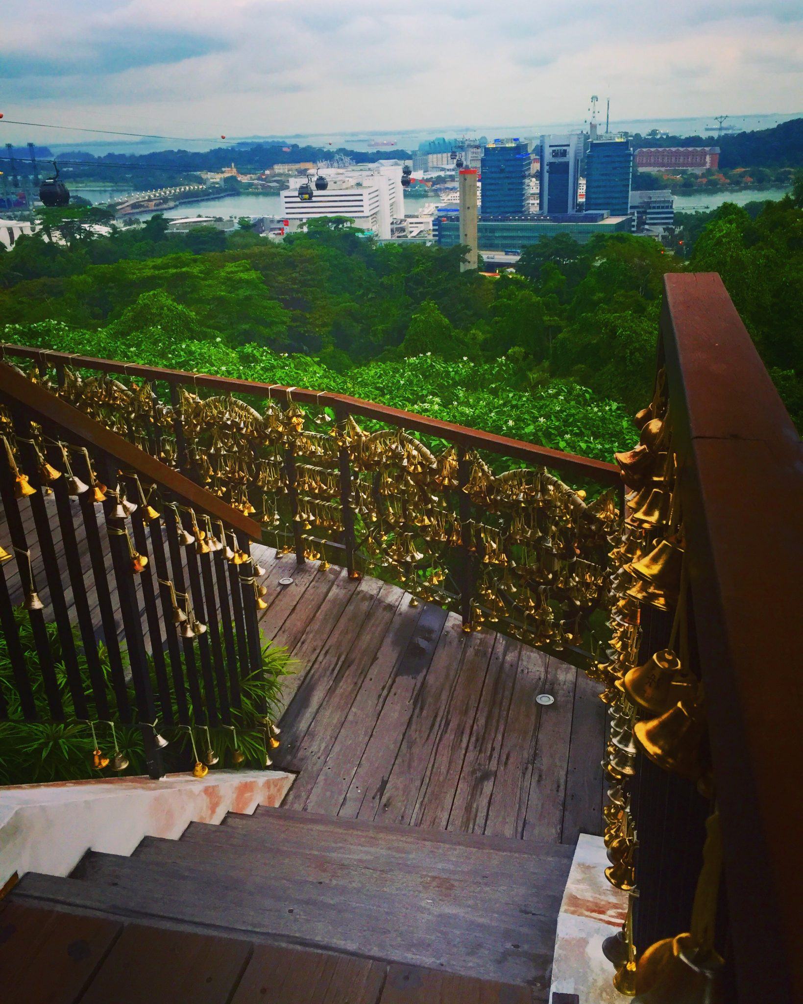 One Day in Singapore: Hidden Gems & Classics 10 wooden stairs surrounded by bells at mount faber with a view of singapore