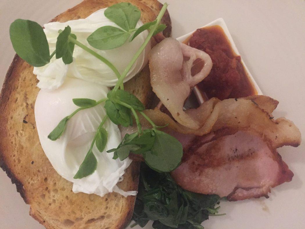 poached eggs adn bacon on taost with greens at fitzrovia