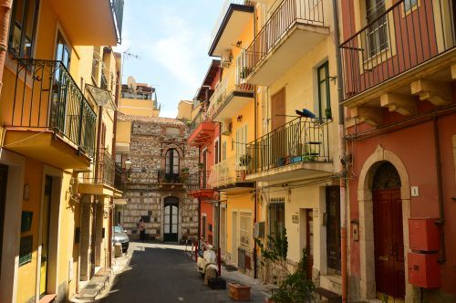 yellow and orange houses on a back street in taormina sicily yellow and orange houses on a back street in taormina sicily