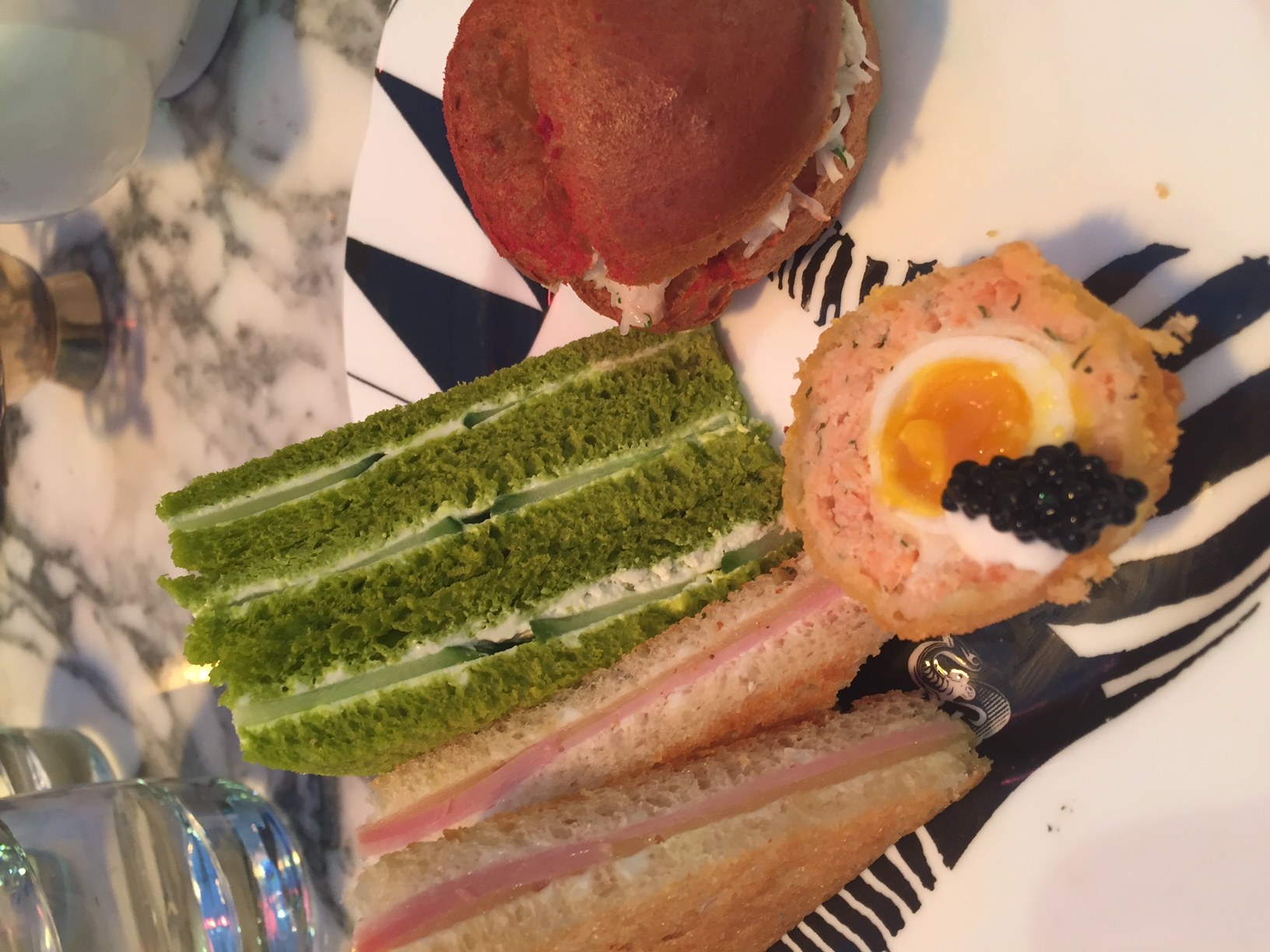 different coloured sandwiches and a scotch egg at afternoon tea london