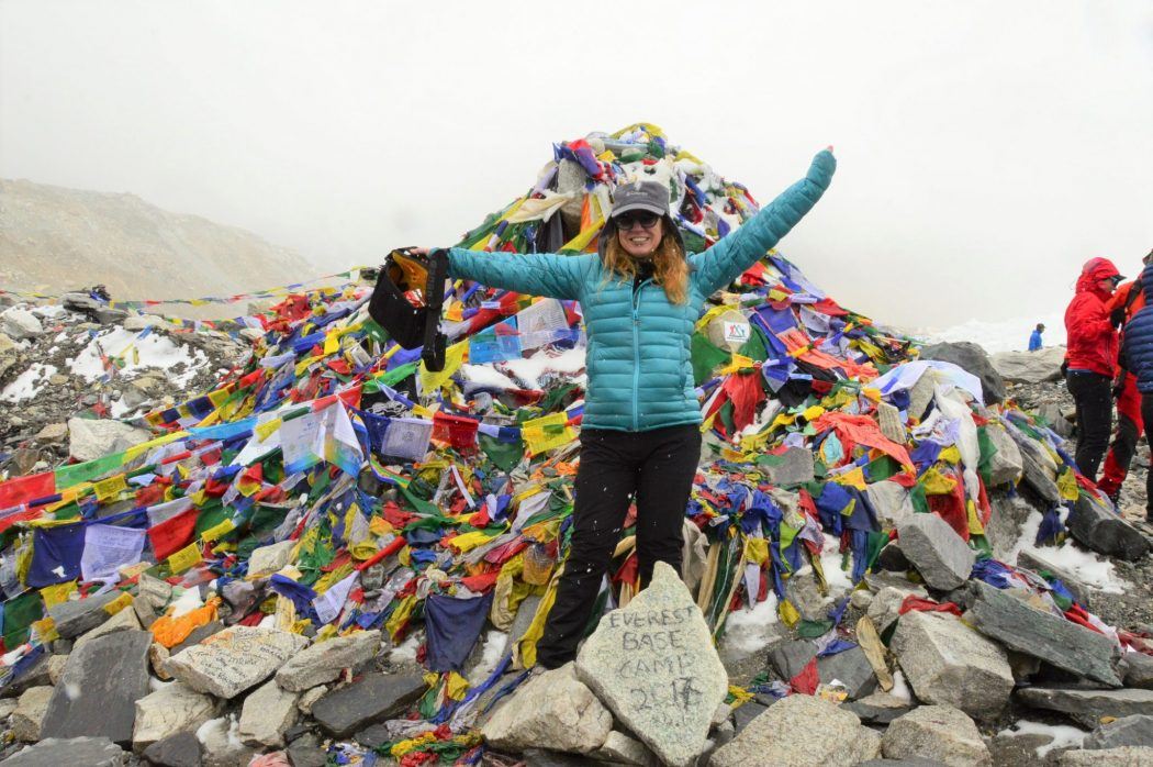 Nepal Tea House: What to Expect on the Everest Base Camp Trek 29 female trekker with arms up at the prayer flags at everest base camp