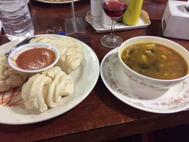 tibetan bread with sauce and a bowl of sherpa stew on a wooden table