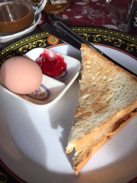 white toast with an egg and jam on a white plate