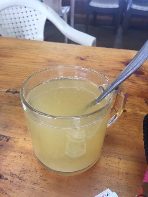 ginger lemon and honey in a clear glass with a spoon 