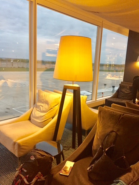 Qatar a380 Business Class Review: Is it Worth It? 7 chair with lamp against a window in the qatar business class lounge at heathrow airport