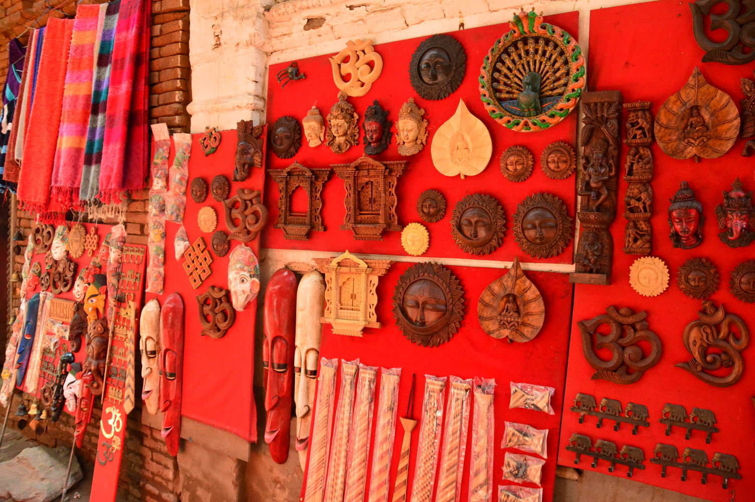 9 Best Places to Visit in Kathmandu & Nearby 9 wooden handicrafts on red cloths up on a wall in bhaktapur
