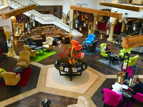 large open room with colourful chairs and a staircase at Arosa Kitzbühel large open room with colourful chairs and a staircase at Arosa Kitzbühel