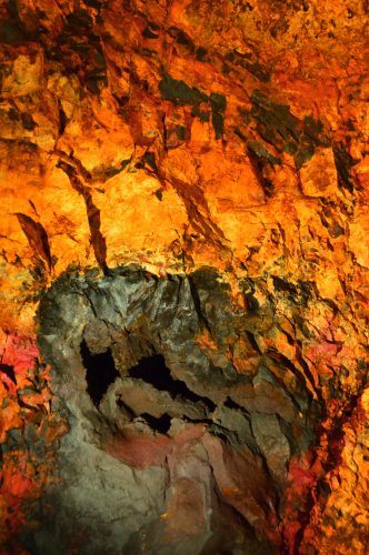 coloured rock walls with a big black area inside the volcano iceland
