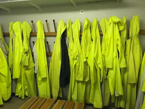 bright yellow rain coats hanging on a hook to be worn for Inside the volcano iceland
