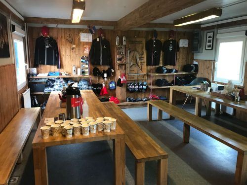 room with tables and benches and drinks wooden which is base camp for the inside the volcano tour iceland