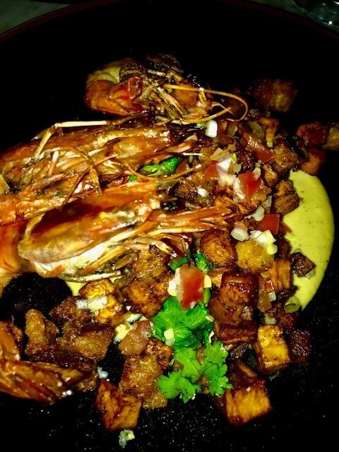 prawns and chopped potatoes on black plate at Oci Medellin