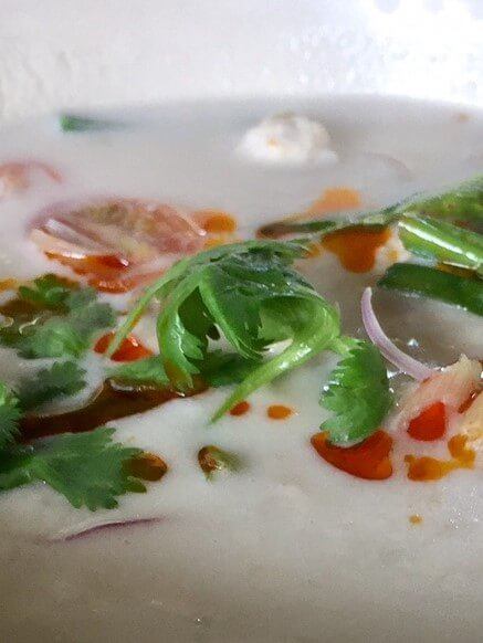 bowl of coconut milk soup and greens