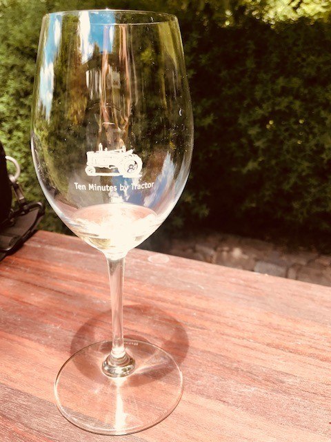 8 Great Things to do Mornington Peninsula 12 wine glass with ten minutes by tractor logo outside on a wooden table