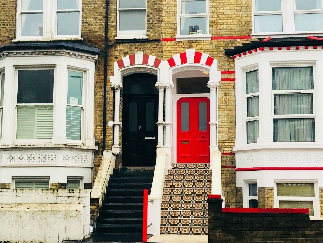 victorian terrace houses with red and black doors in clapham