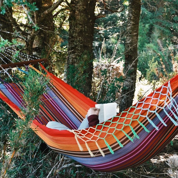 colourful hammock in the forest with a person inside