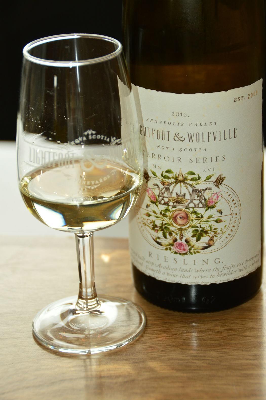 Lightfoot & Wolfville wine bottle and glass of white wine