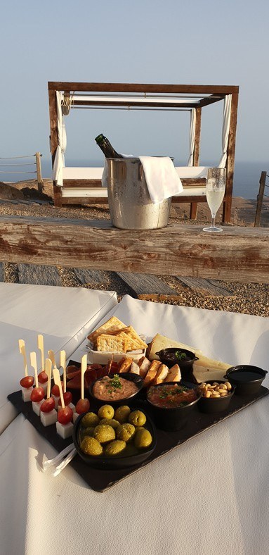 8 Best Things to do in Maspalomas 16 plate of snacks, bottle of wine in a bucket and a sun bed at Salobre resort gran canaria