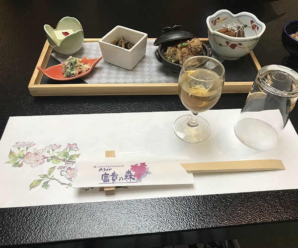Nakasendo Trail and What to Expect at a Japanese Ryokan 8 typical japanese meal with multiple dishes, a glass of sake and chopsticks