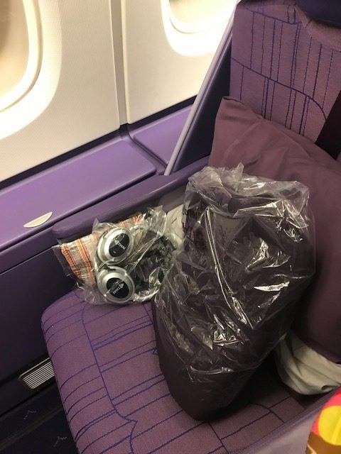 business class bangkok to london seat with pillow and headphones