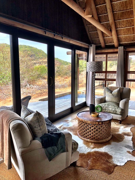 Travel Expert Packing List for Safari 4 2 armchairs with glass wall and view of outside at kwandwe safari south africa