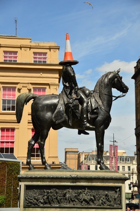 statue in glasgow with orange cone