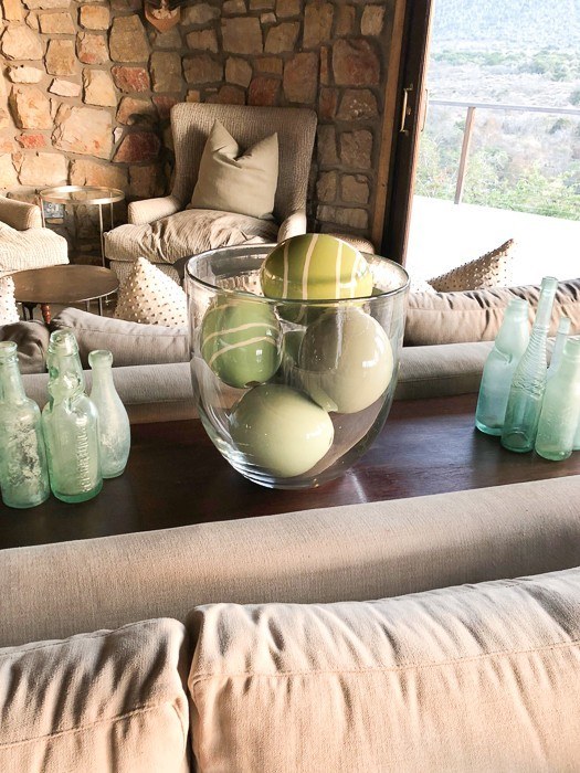 green ostrich eggs in a glass vase in a living room at kwandwe