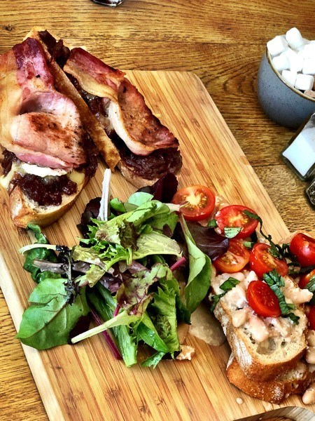 6 Cafes in Exeter Not to Miss 14 open sandwiches with bacon, tomatoes and lettuce on a wooden board