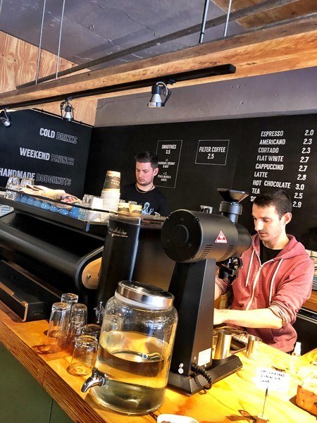 6 Cafes in Exeter Not to Miss 16 men behind big coffee machine and coffee menu at March coffee exeter