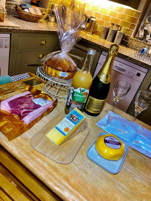 11 Best Cotswolds Tour from London Options and Top Tips 17 food and drinks on a wooden table in Bruern cottage - welcome pack