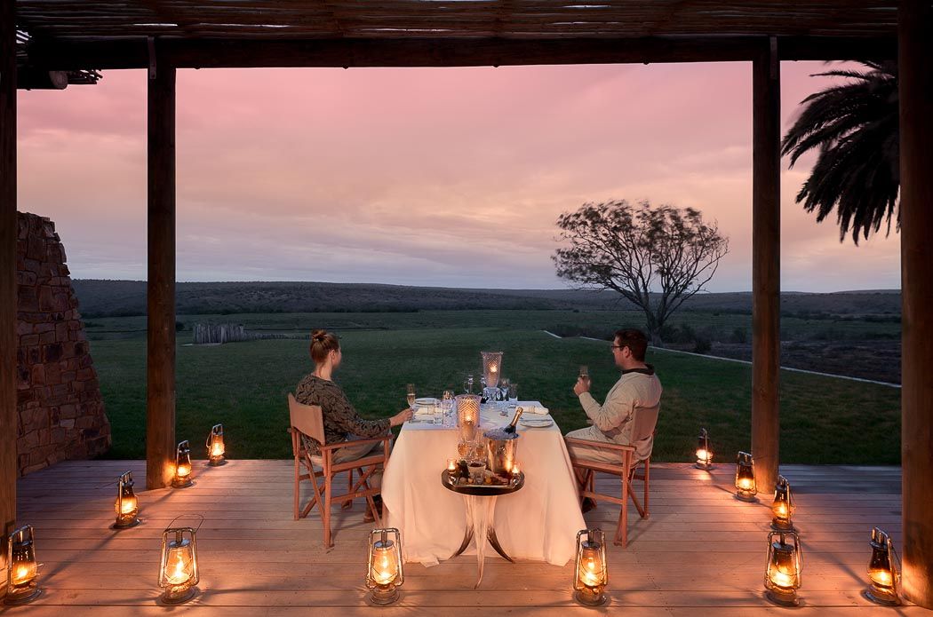 couple having dinner on an open deck with lots of lanterns in south africa