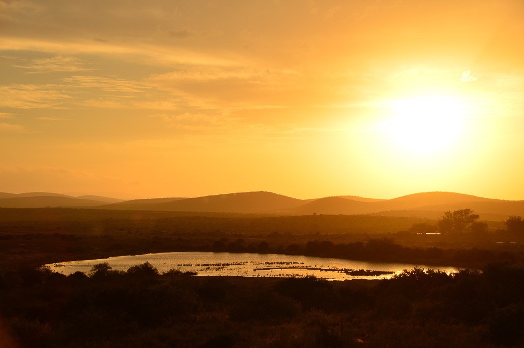 Sunset across african plains with a lake in foreground