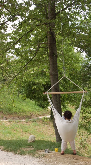 woman in a sitting hammock hanging from a tree