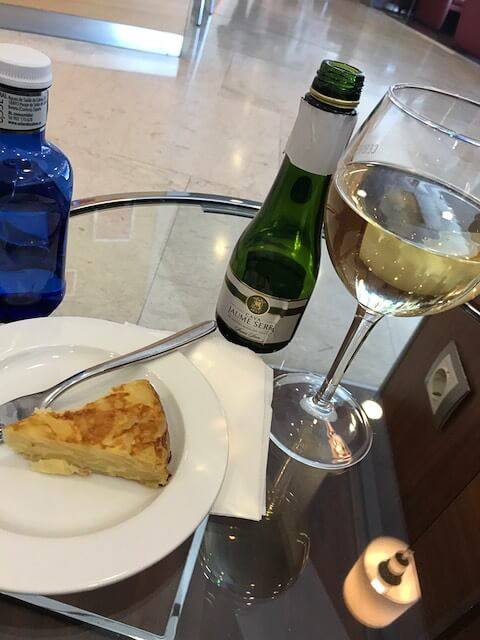 Iberia Business Class Review: Is it Worth It? 2 plate with tortilla glass of wine on a table in the iberia business class lounge