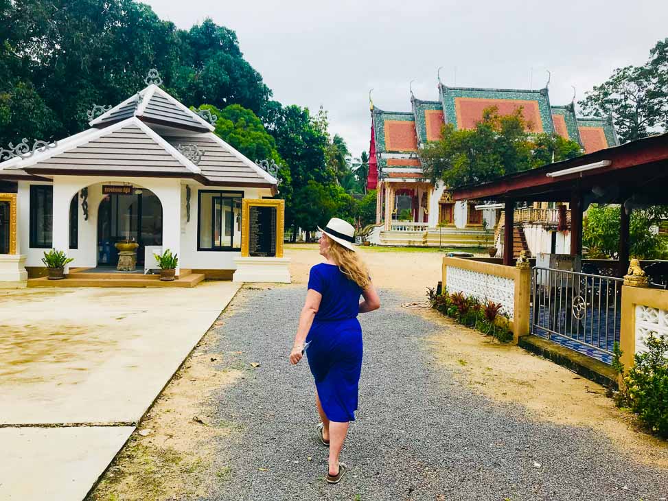 woman in hat from behind with thai temples