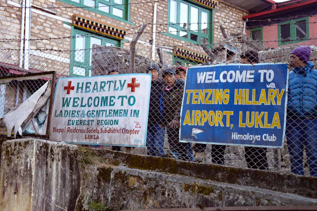 signs against railing at lukla airport on my everest base camp trek blog