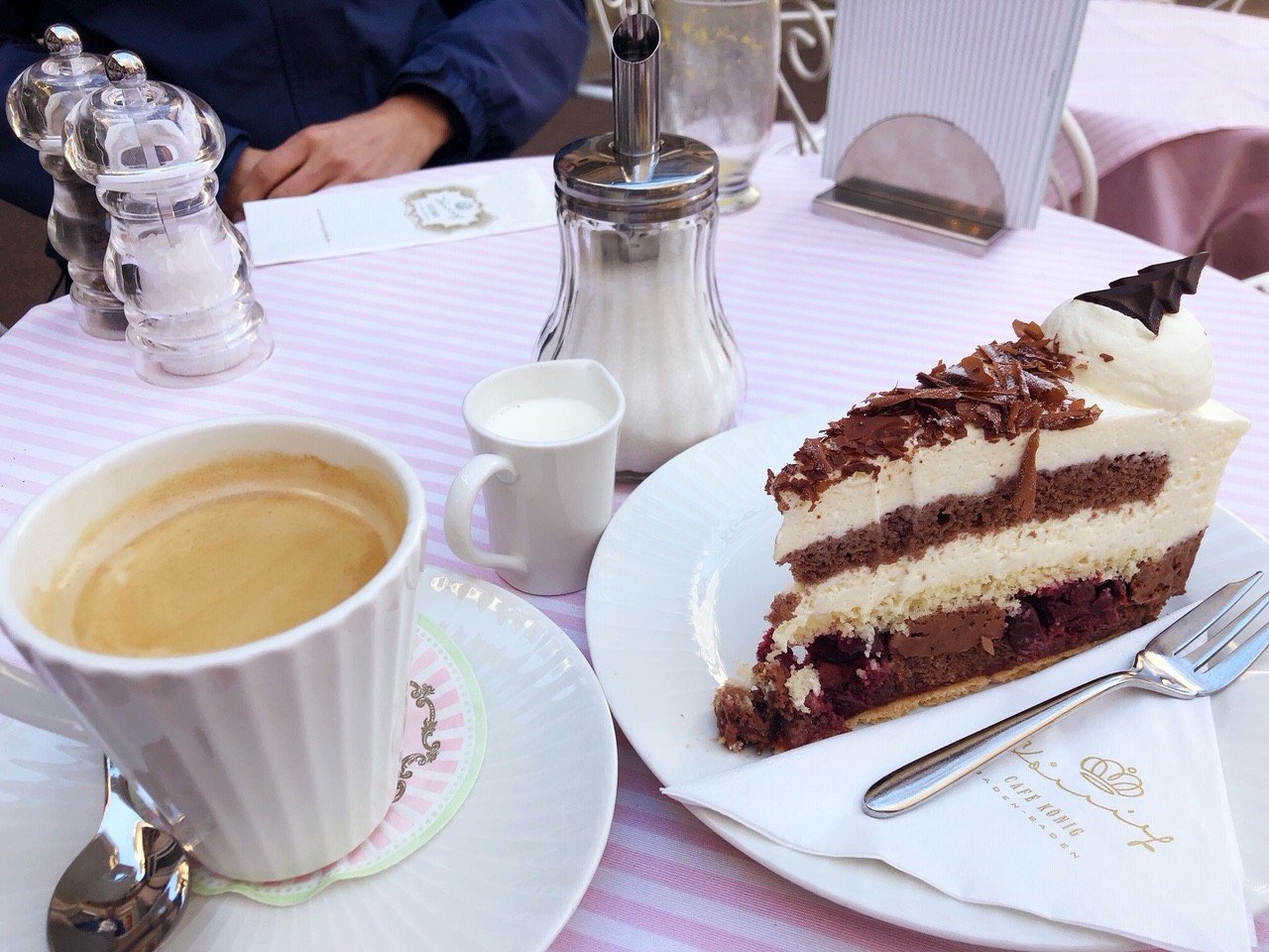Baden-Baden Spa Guide: Naked or Clothed? (2022) 25 coffee and slice of black forest cake set on a pink table at Cafe Koenig