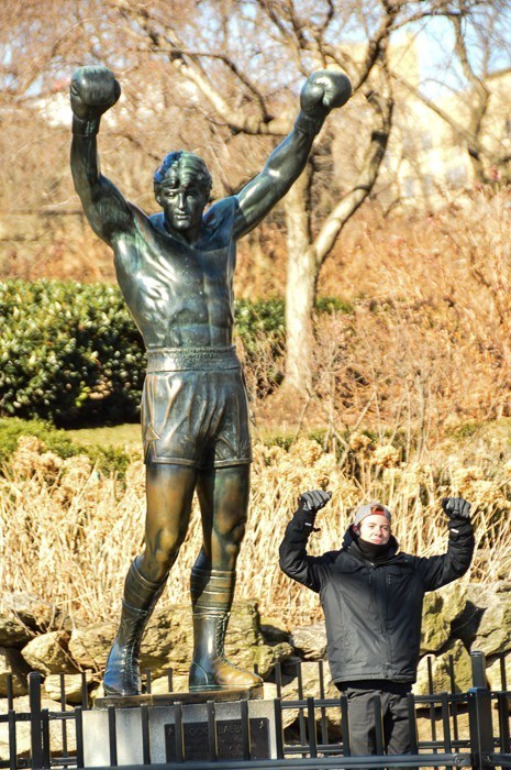 rocky statue in philadelphia with man posing in front