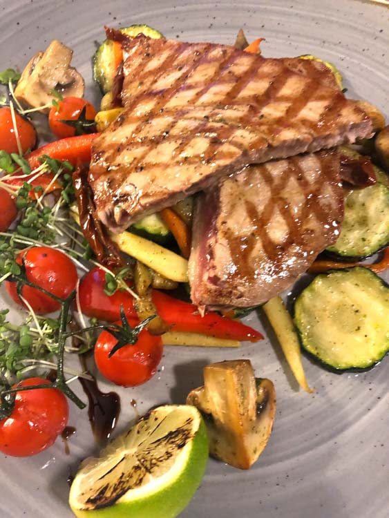 Tuna steak with vegetables on plate at hotel kurshi restaurant jurmala