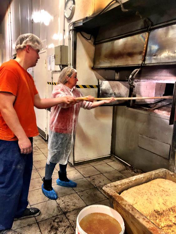 laci bakery oven with people putting in loaves