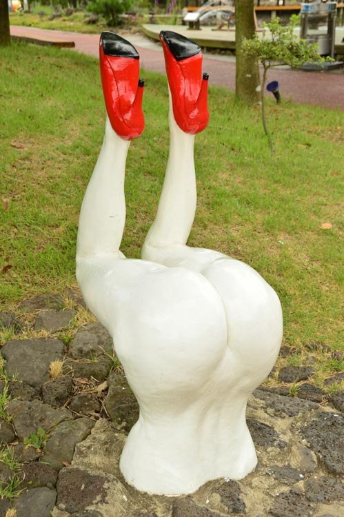 sculpture of upside down naked woman wearing red heels