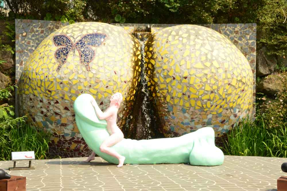 woman on phallic sculpture at Jeju Island Loveland