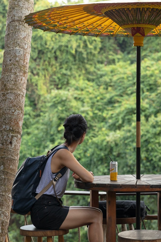 person sitting at table looking at forest in bali