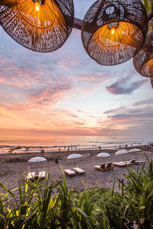 sunset view of beach in bali with lights in foreground
