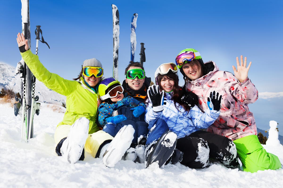 Happy friends after skiing sit on snow wave hands