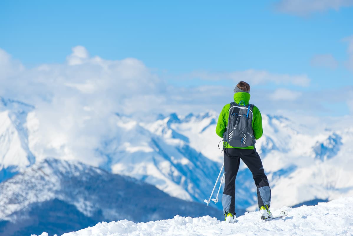 7 Best Ski Resorts Italy | Italian Alps and the Dolomites 5 solo skier in green jacket looking over snowy mountains