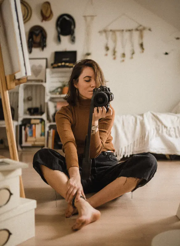 woman sitting on carpet playing with a camera