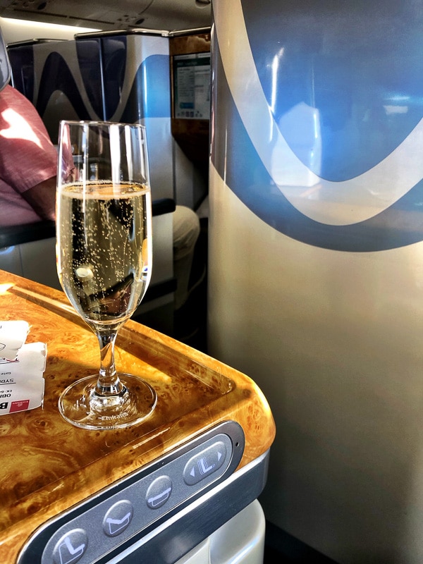 Emirates Business Class Review: Is it Worth It? 9 glass of champagne on seat side rest emirates business class