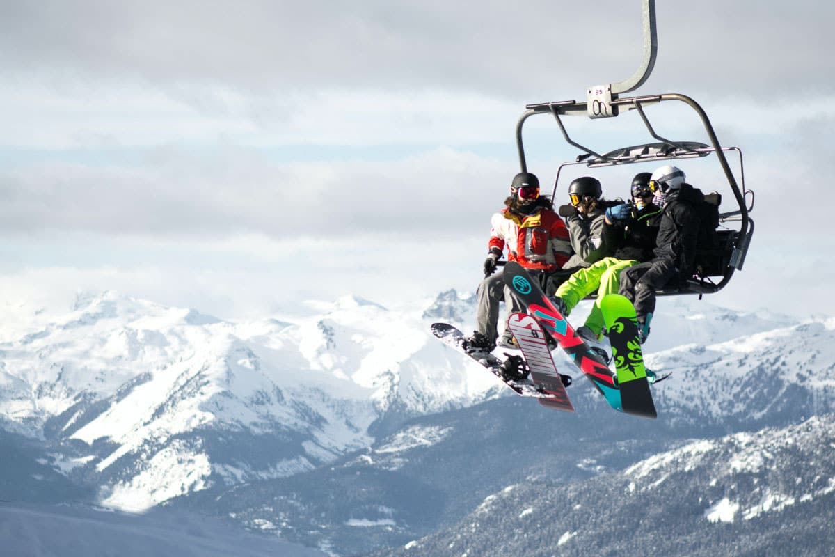4 people in chair lift over mountain in italy